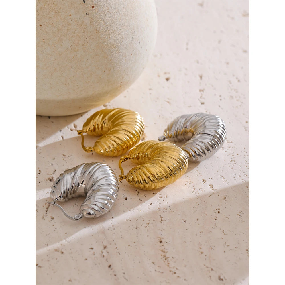 Lifestyle photo layering earrings and gold accents with chunky hollow hoops