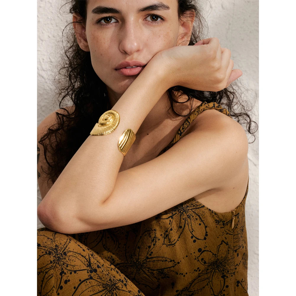 Close angle of a gold bracelet showing polished gold plated surface