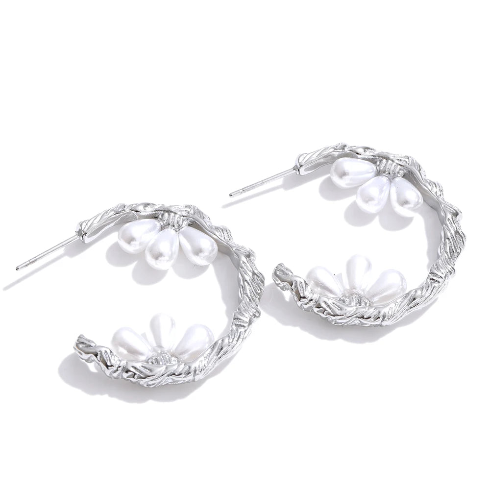 Front view of gold plated pearl hoop earrings on white background