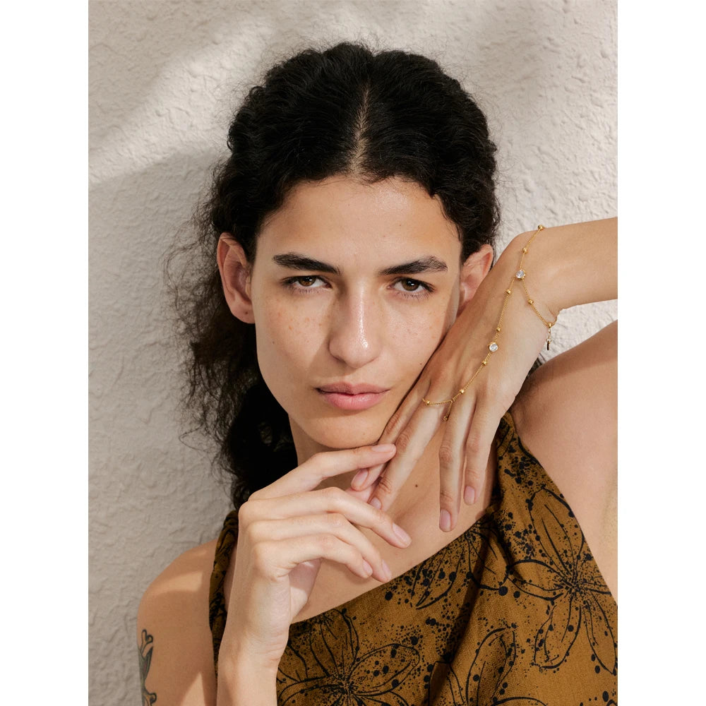 Close view of hand chain showing finger for rings connection with gold jewelry finish