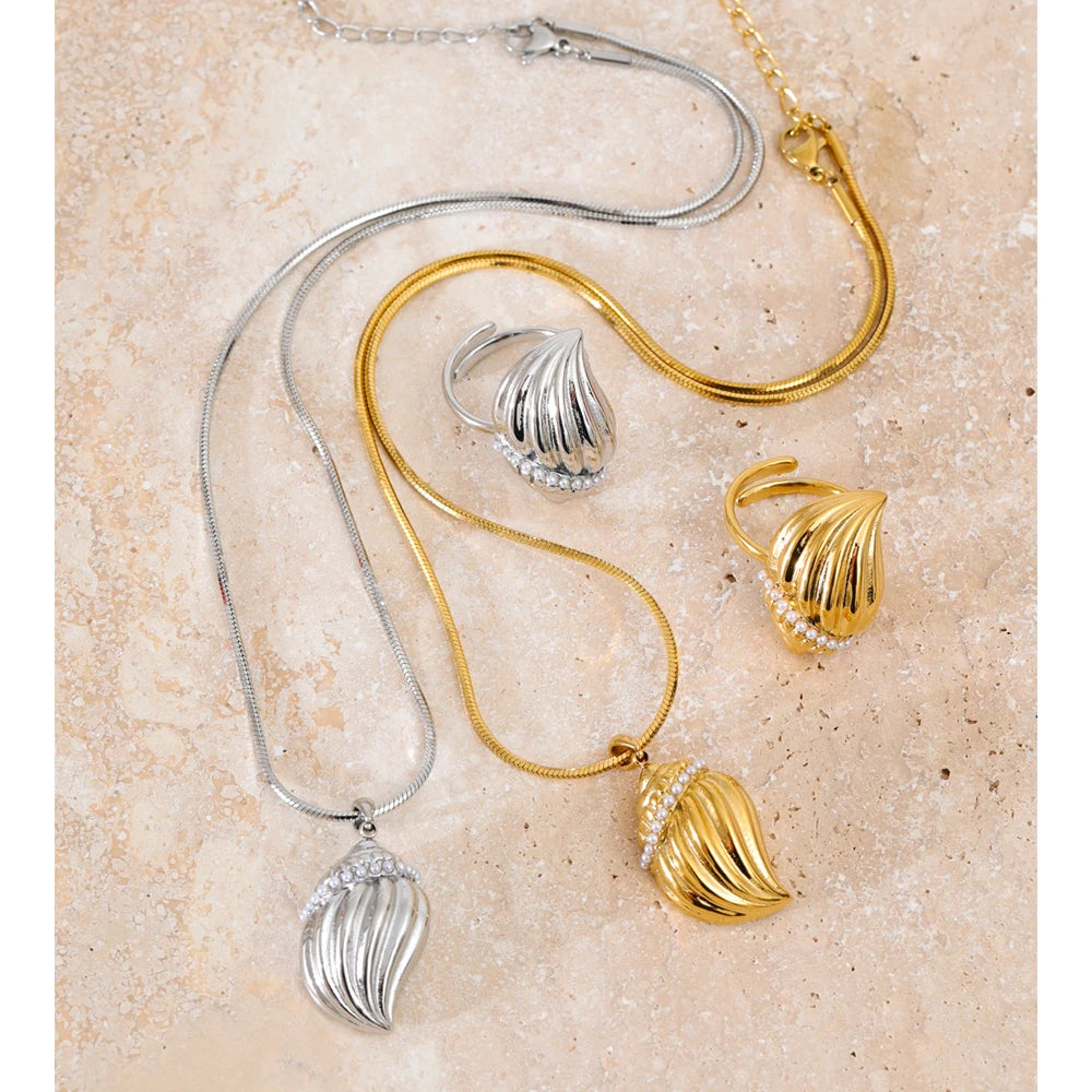 Close view of charm necklace conch pendant layered in a necklace and necklace style