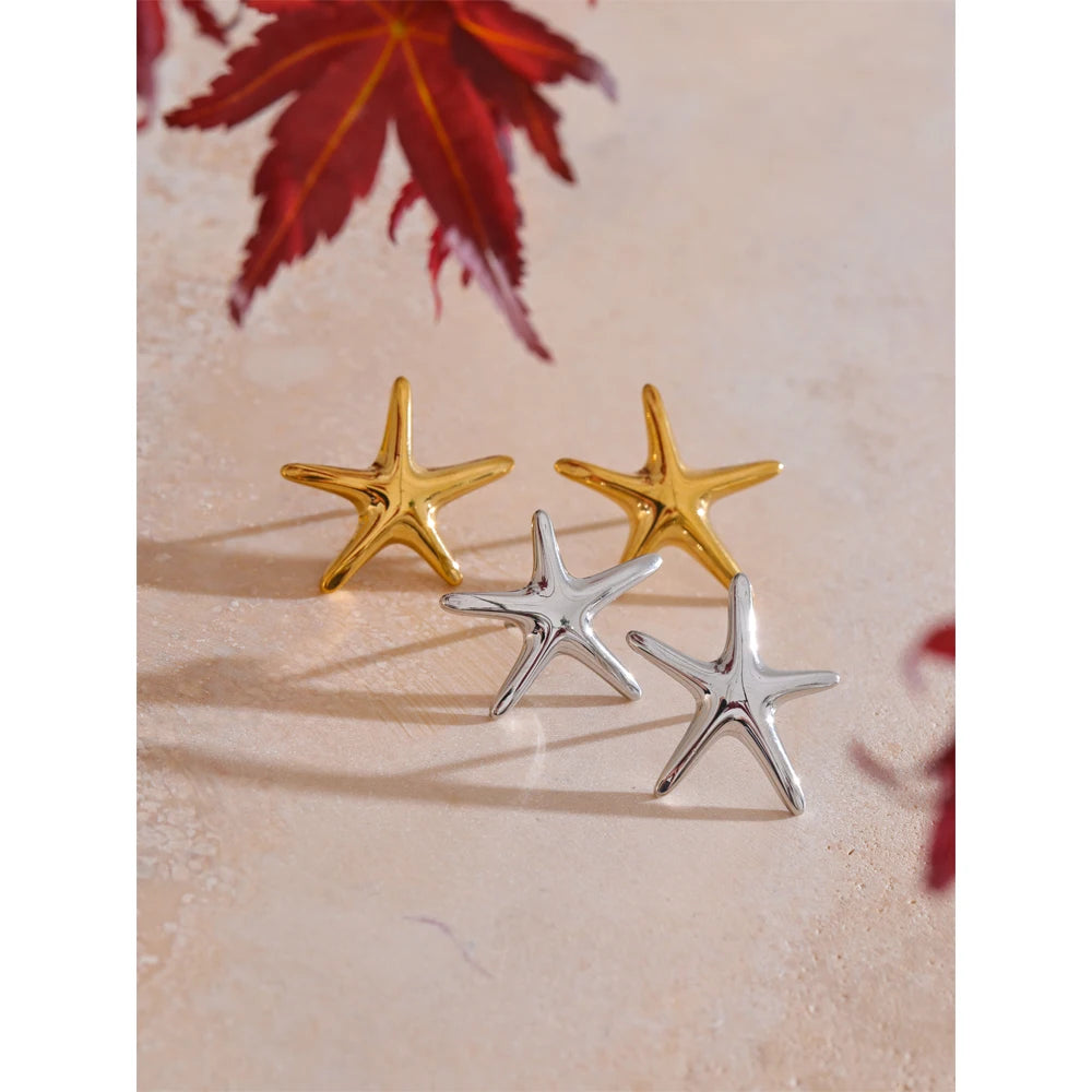 Jewelry flat lay of starfish stud earrings with a gold earrings accent