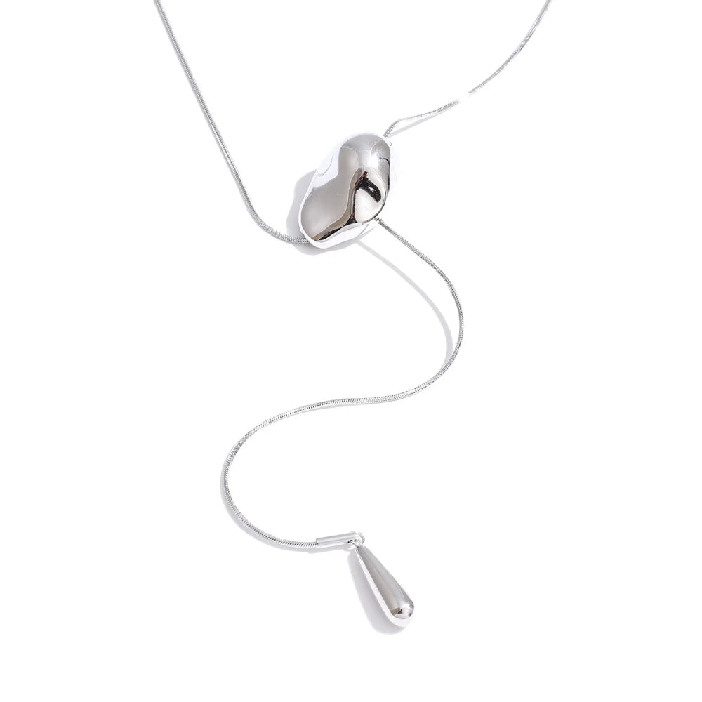 Modern geometric drop necklace paired with a refined outfit