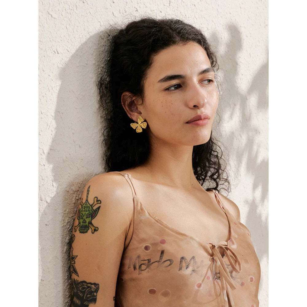 Close view of butterfly earrings as ear rings with smooth posts and gold jewelry finish