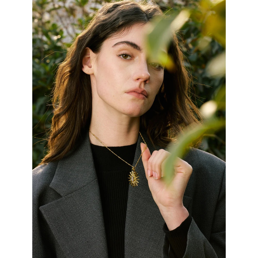 Minimal studio shot of pendant on a necklace highlighting necklace with gold glow