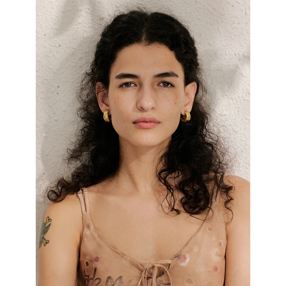 Close view of hoop earrings showing polished gold plated shine for gold women style