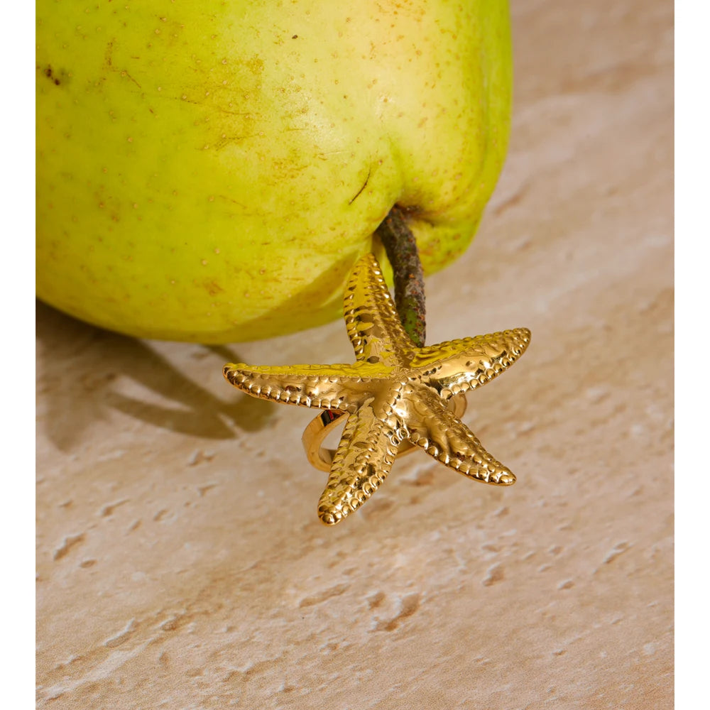Finger with a ring showing golden starfish shape