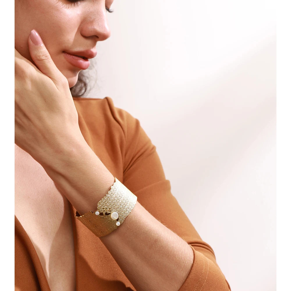 Cuff bracelet in gold layered with bracelet bracelets for a chic stack