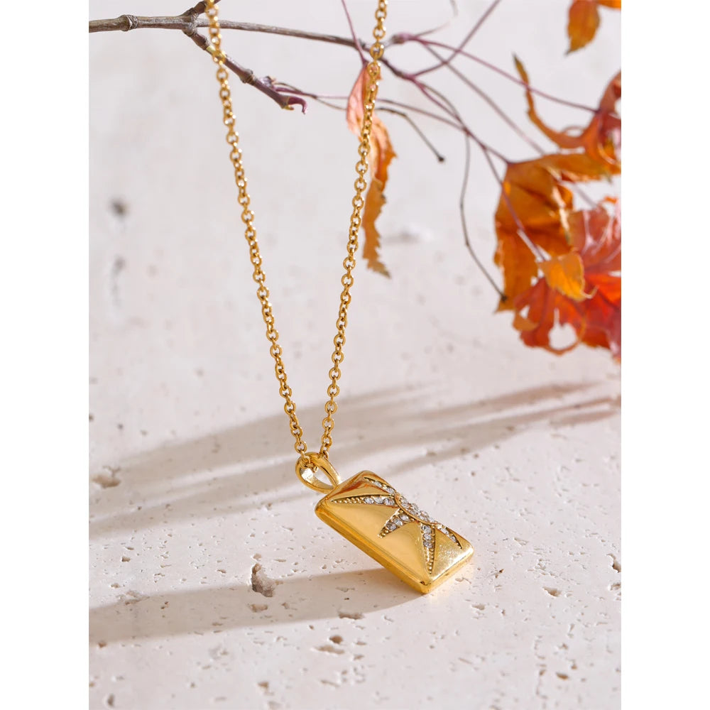 Close view of charm necklace showing cubic zirconia detail on necklace with gold