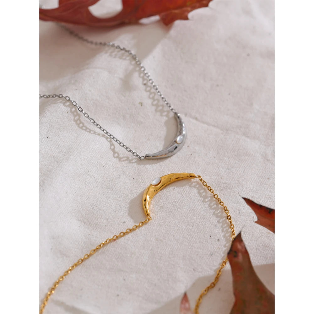 Close view of pendant on a necklace featuring seashell and moon charm