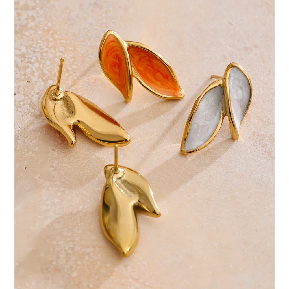 Close up of gold earrings gold with enamel leaf detail